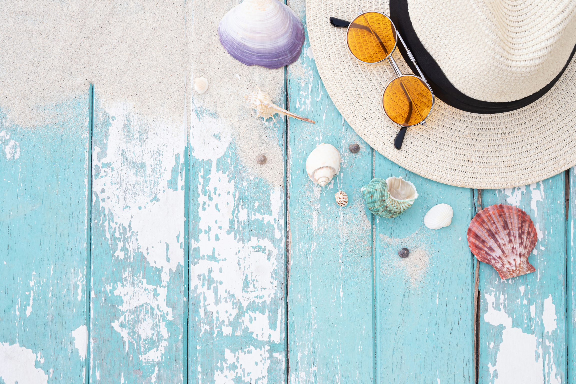 Sun Hat, Shades and Seashells on Blue Wooden Planks